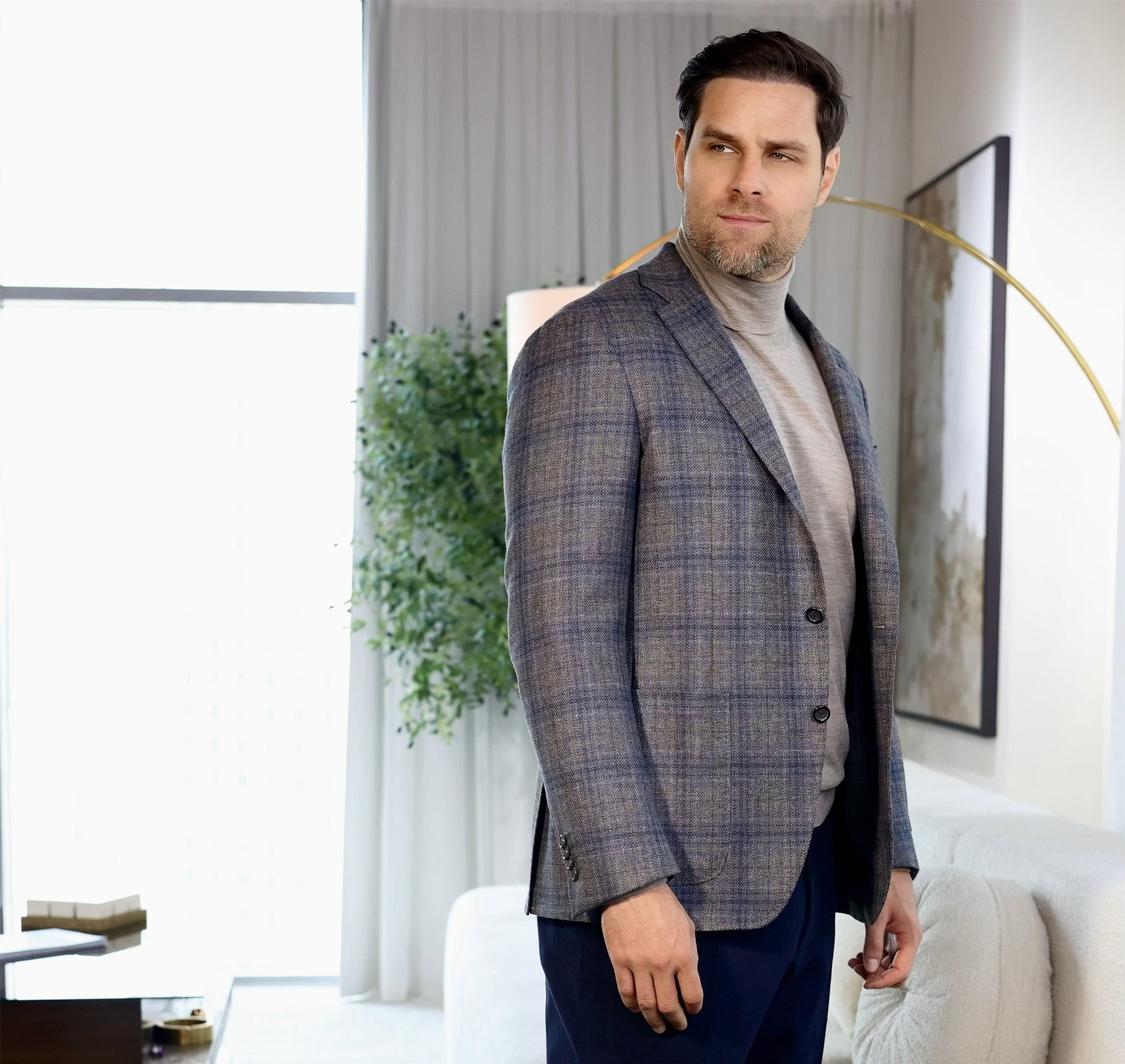 Man wearing a checkered blazer in a modern living room